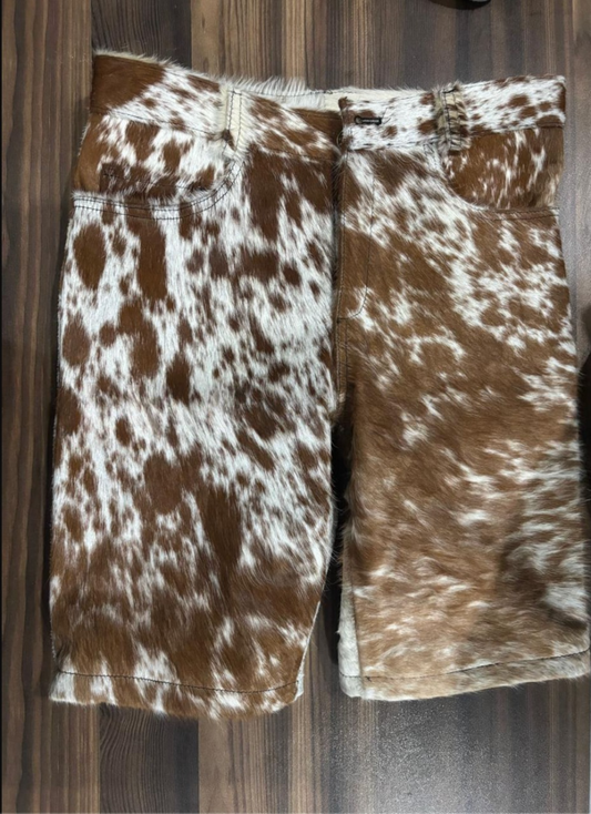 Men’s cowhide shorts made from genuine hair-on leather with brown and white patterns, designed for streetwear appeal and western-inspired styling with a bold silhouette.