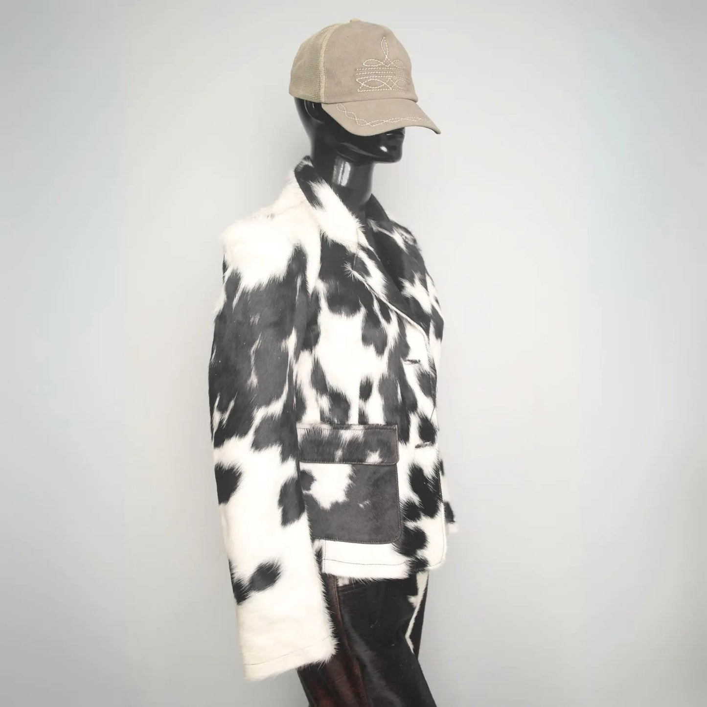 Black and white cowhide fur coat with natural hide pattern. Warm western jacket for rodeo styling, ranch wear, and unisex winter country fashion.