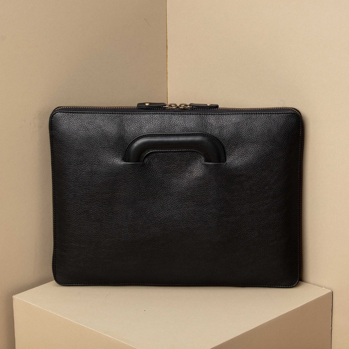 Schwarze Laptoptasche aus Leder mit Griffen und zwei Fächern für Laptop und Unterlagen. Ideal für Büro, Arbeit und Reisen.