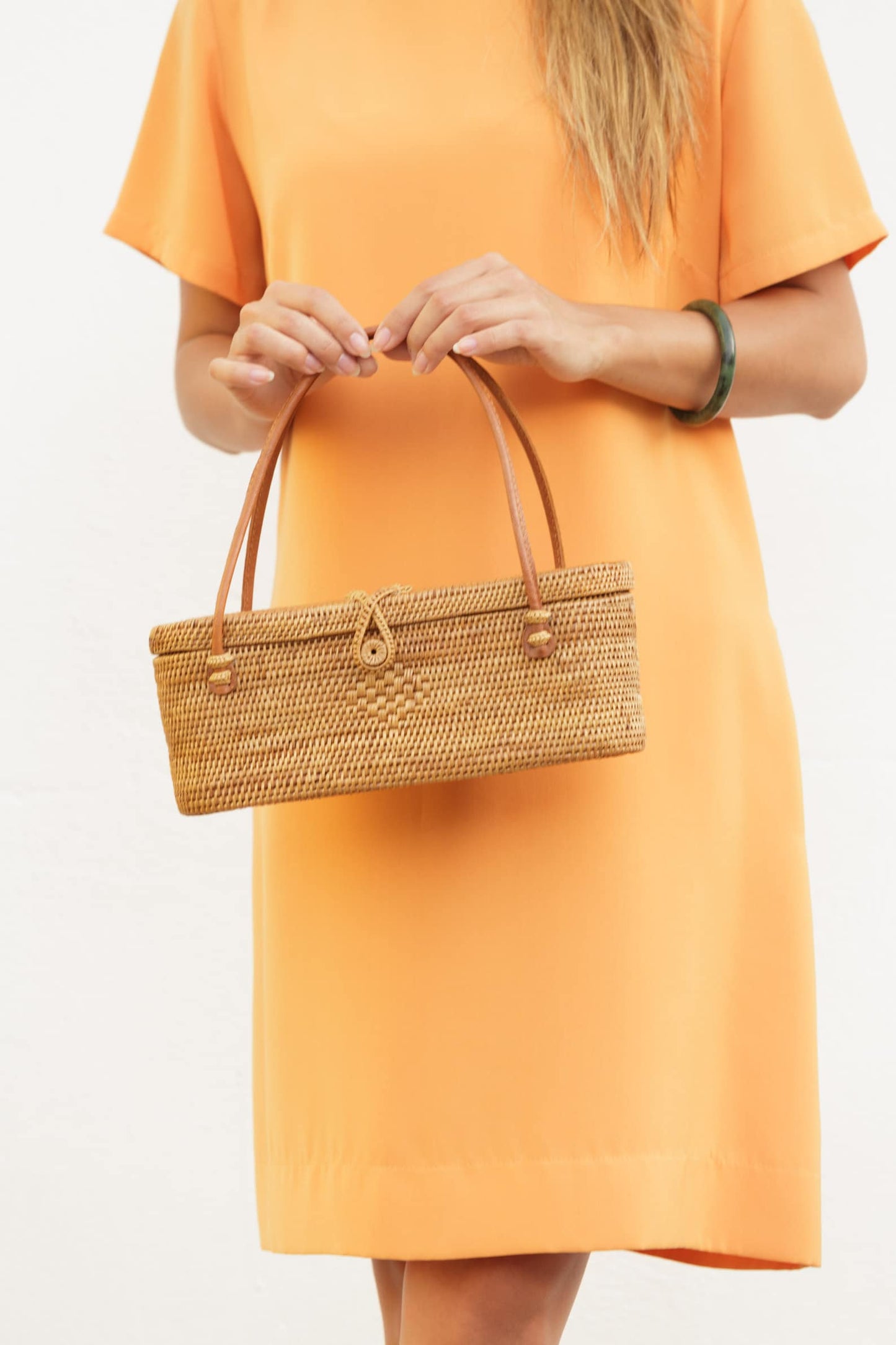 Elegant handcrafted rattan handbag with a unique oval shape, perfect for summer outings. Lightweight and easy to carry, adding a natural touch to any casual look.