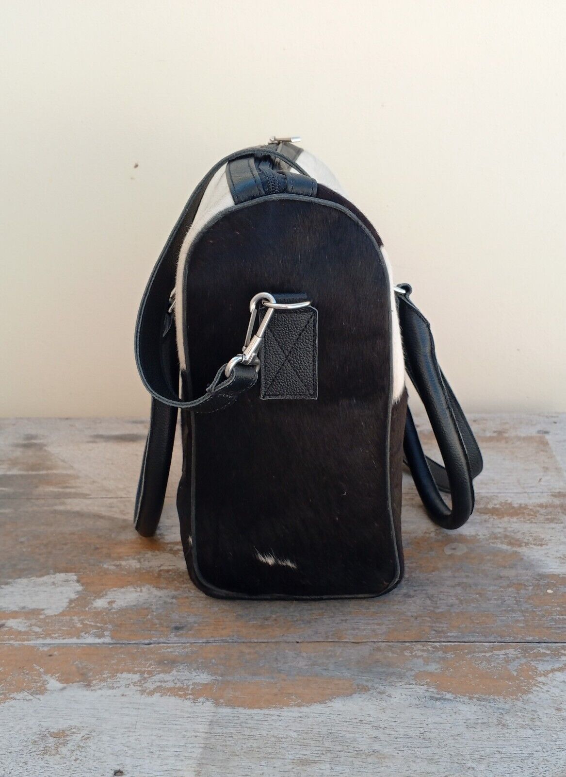 Fashionable woman carrying a cowhide shoulder bag in a park.