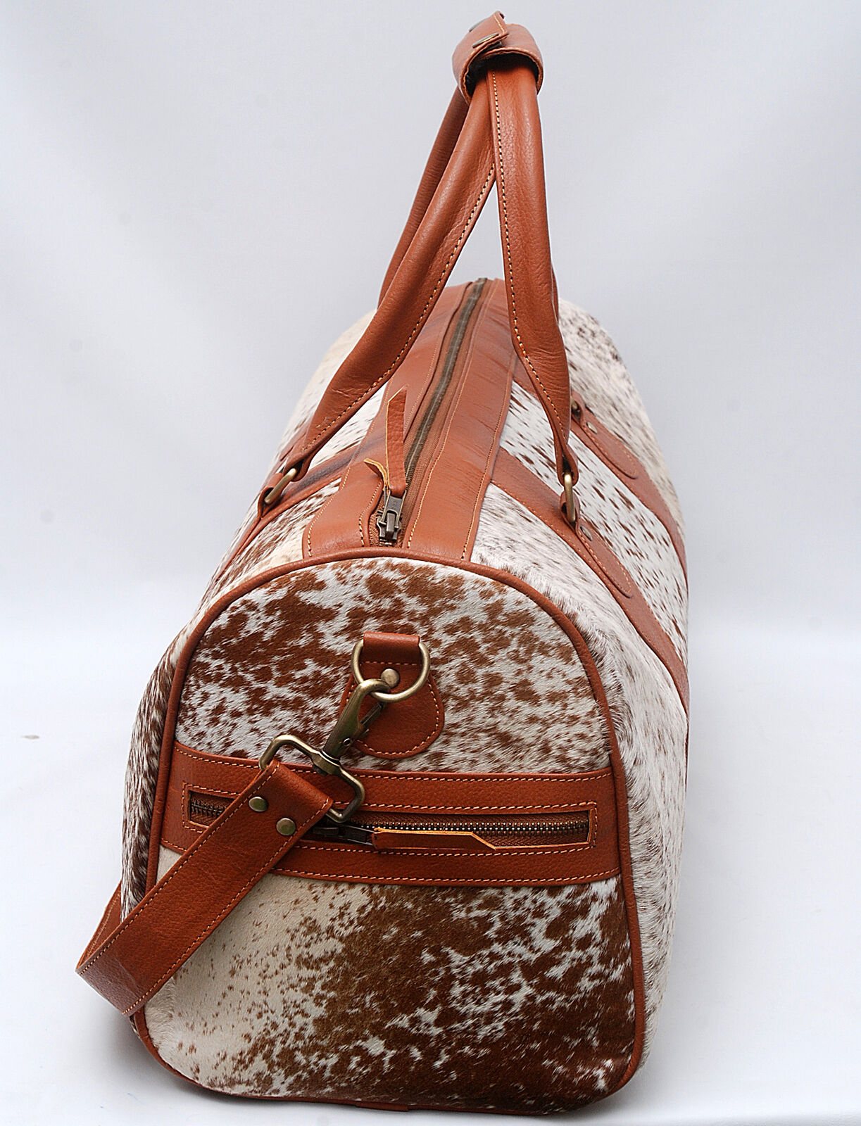 Unleash your wanderlust with this cowhide travel bag, a blend of rugged charm and urban sophistication.
