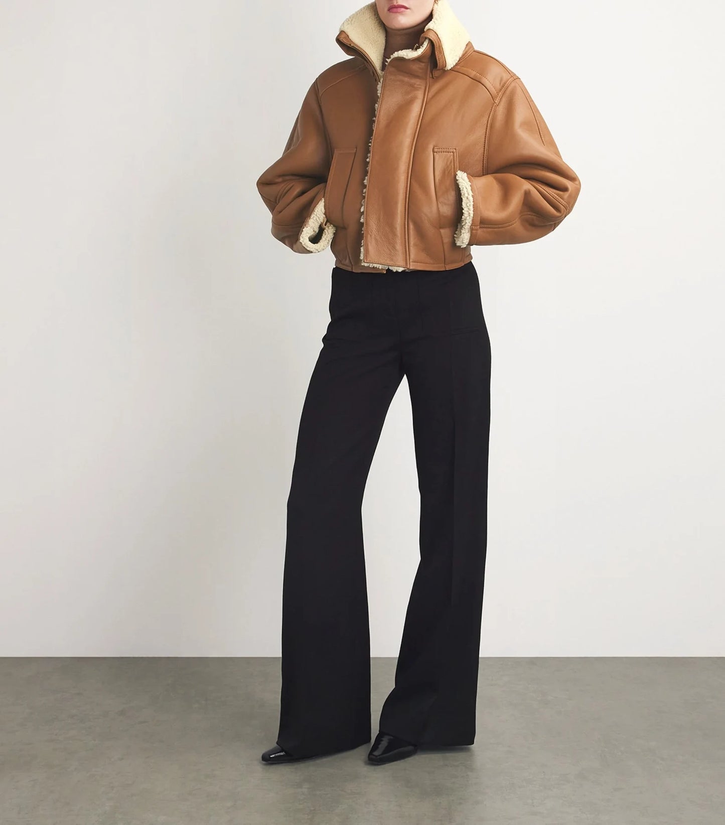 Chic women's leather jacket on a hanger, showcasing a tailored fit, smooth texture, and stylish design.