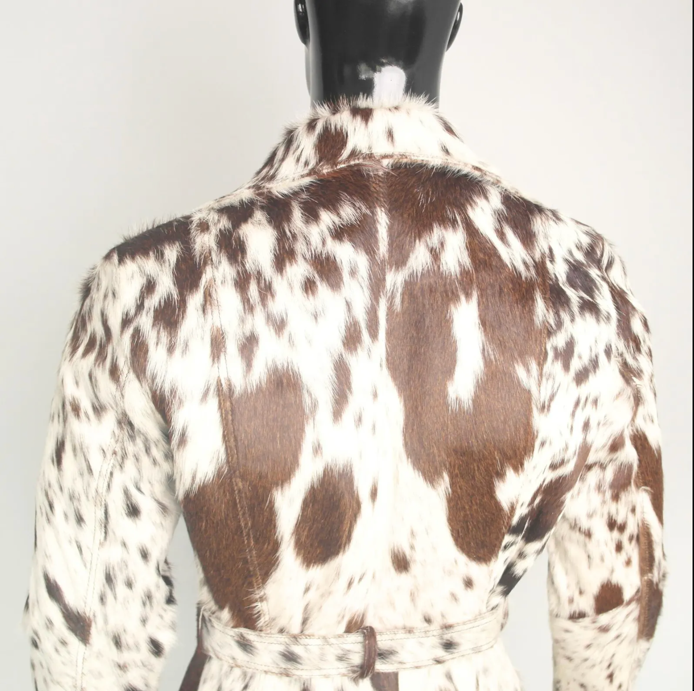 Hair on cow hide coat with belt and lapels, designed for women seeking western-style outerwear with real cowhide texture.