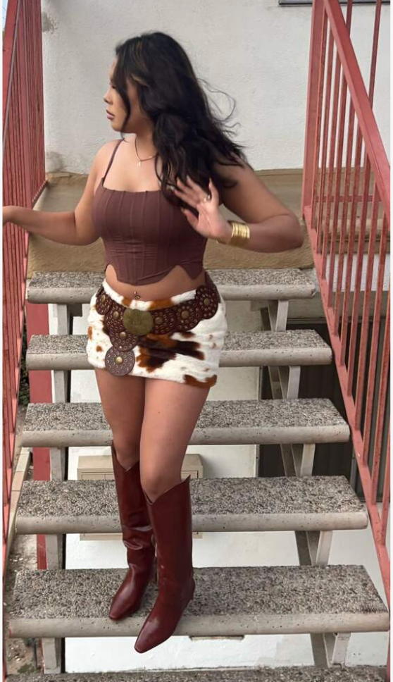 A bold cowhide skirt made from natural cow fur, featuring distinctive brown and white patterns in a high-rise mini cowhide skirt silhouette.