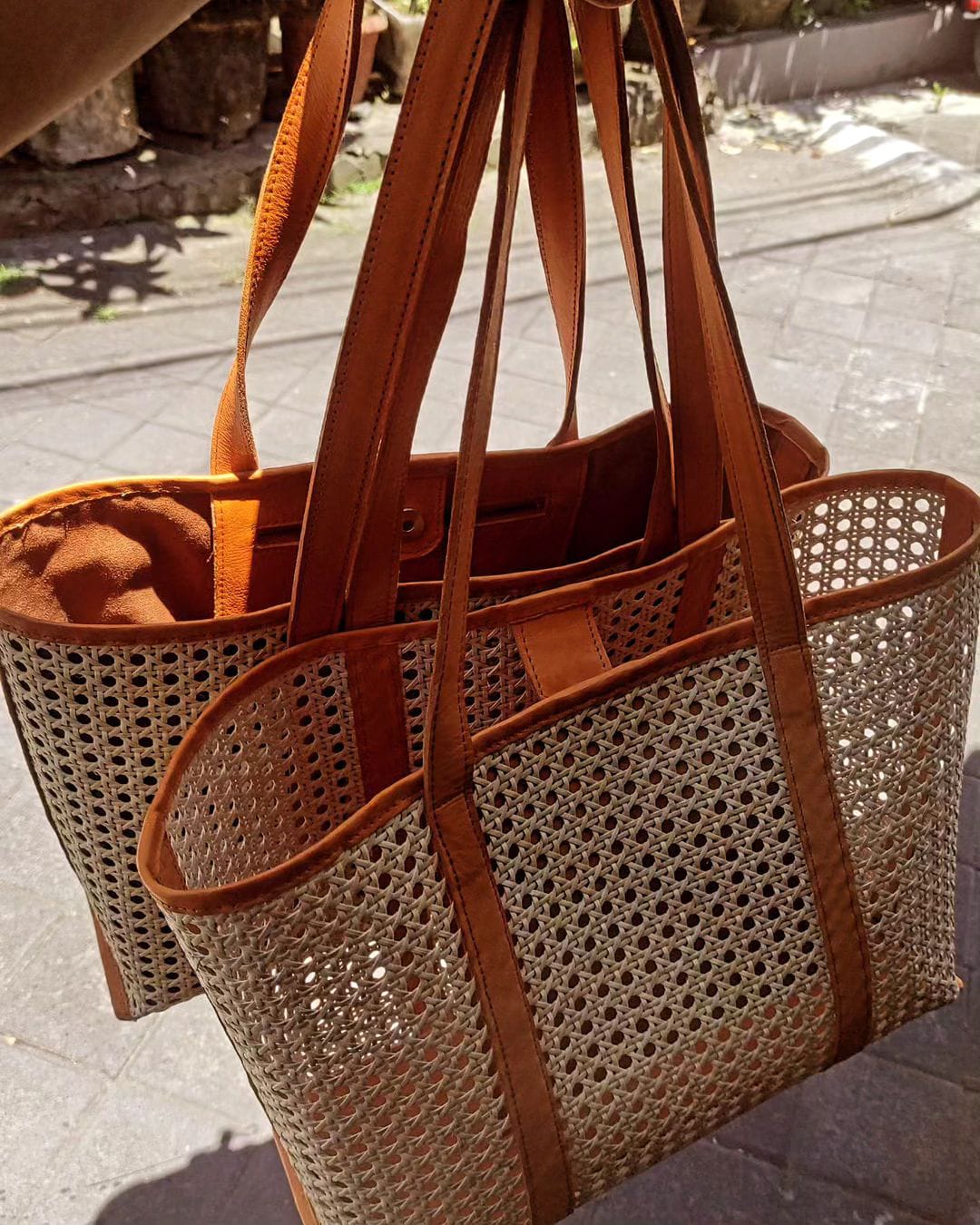 Elegant woman holding a rattan beach bag, perfectly complementing her summer beach outfit with the bag's rustic charm and spacious design
