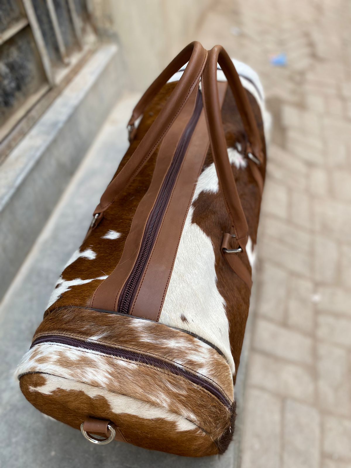 Brown and White Cowhide Duffle Bag for Travel and Overnight Use