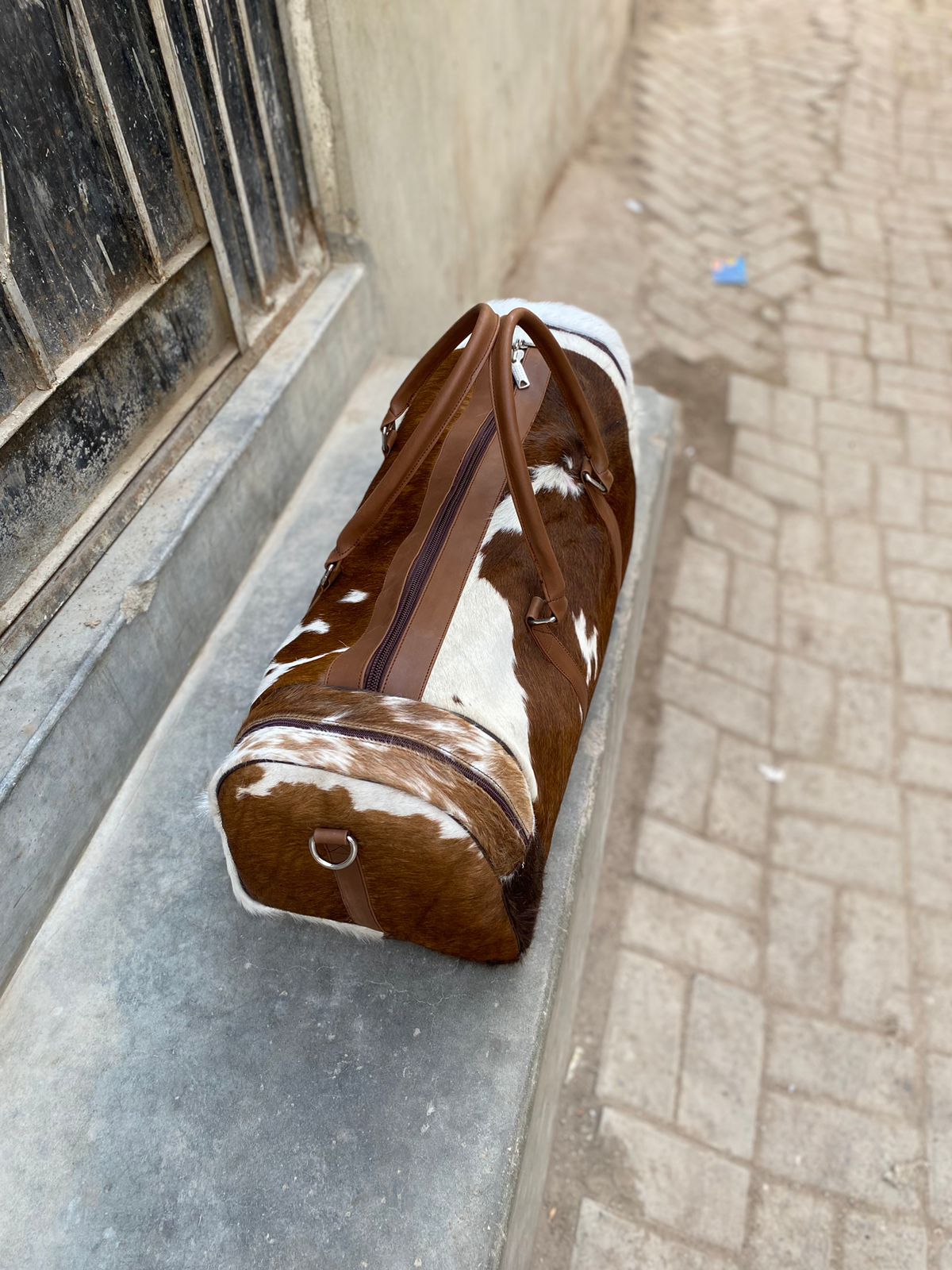 Brown and White Cowhide Duffle Bag for Travel and Overnight Use