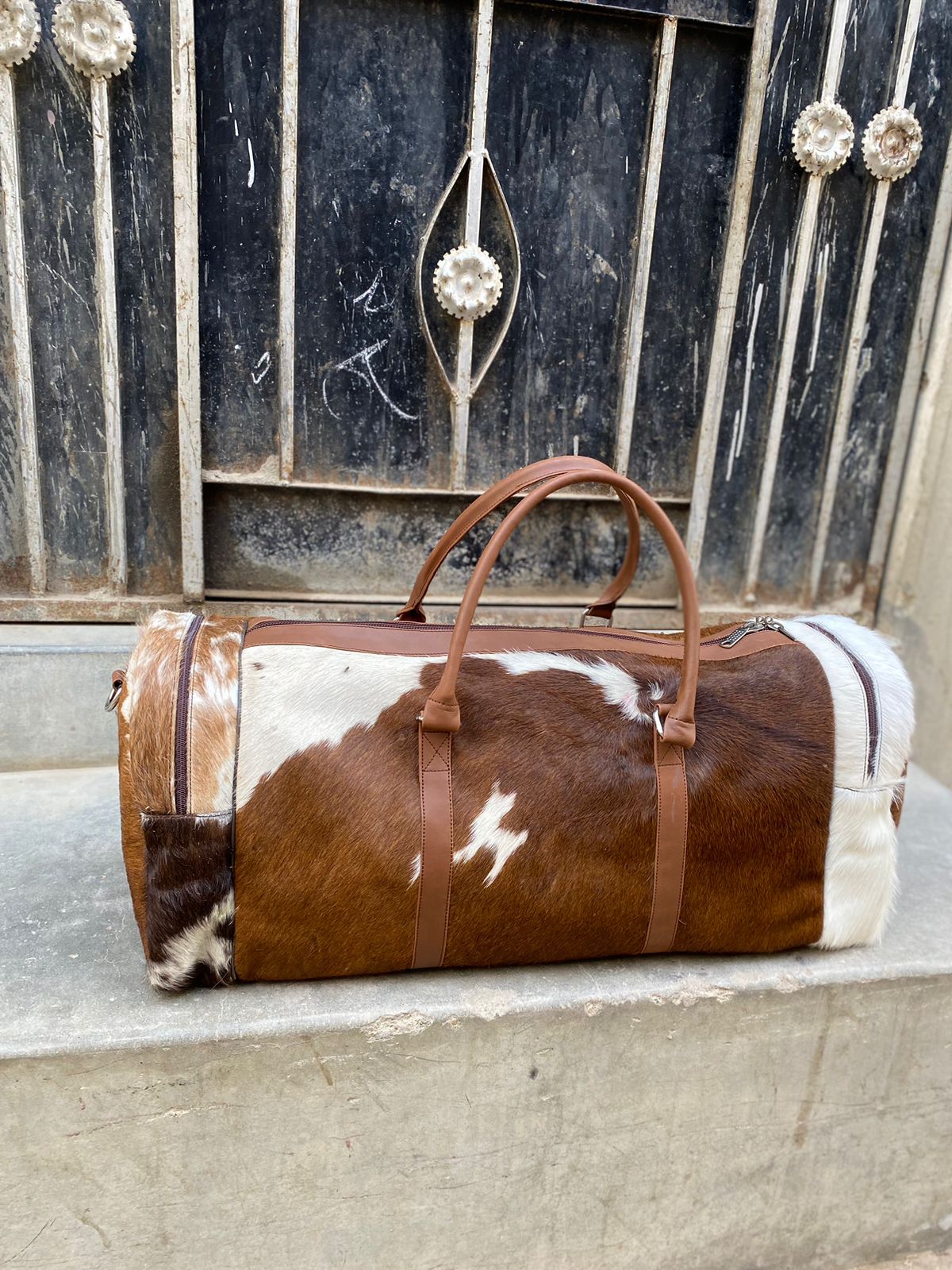 Brown and White Cowhide Duffle Bag for Travel and Overnight Use