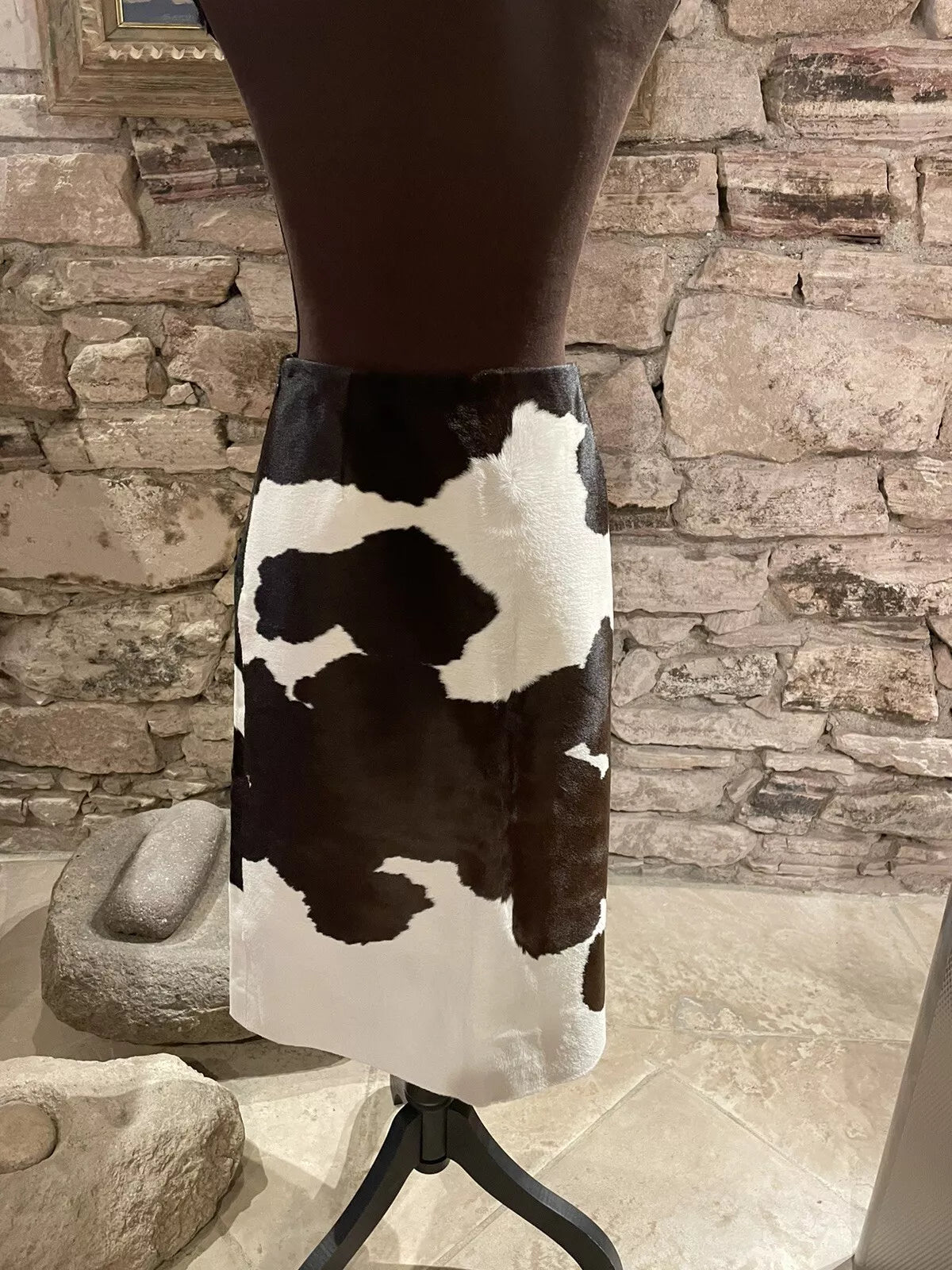 Black and white cowhide patterns bring a bold touch to this western-inspired skirt. Ideal for cowgirl looks and rodeo events.