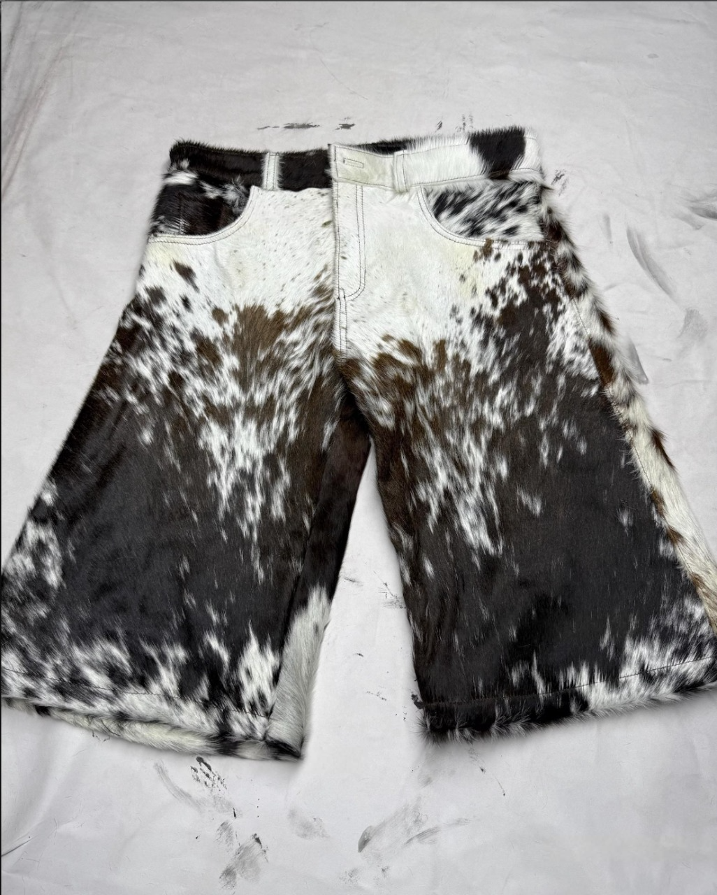Real cowhide men shorts in black and white speckled pattern, designed for rodeo events, cowboy outfits, western parties, and country weddings. Unique cow fur texture.