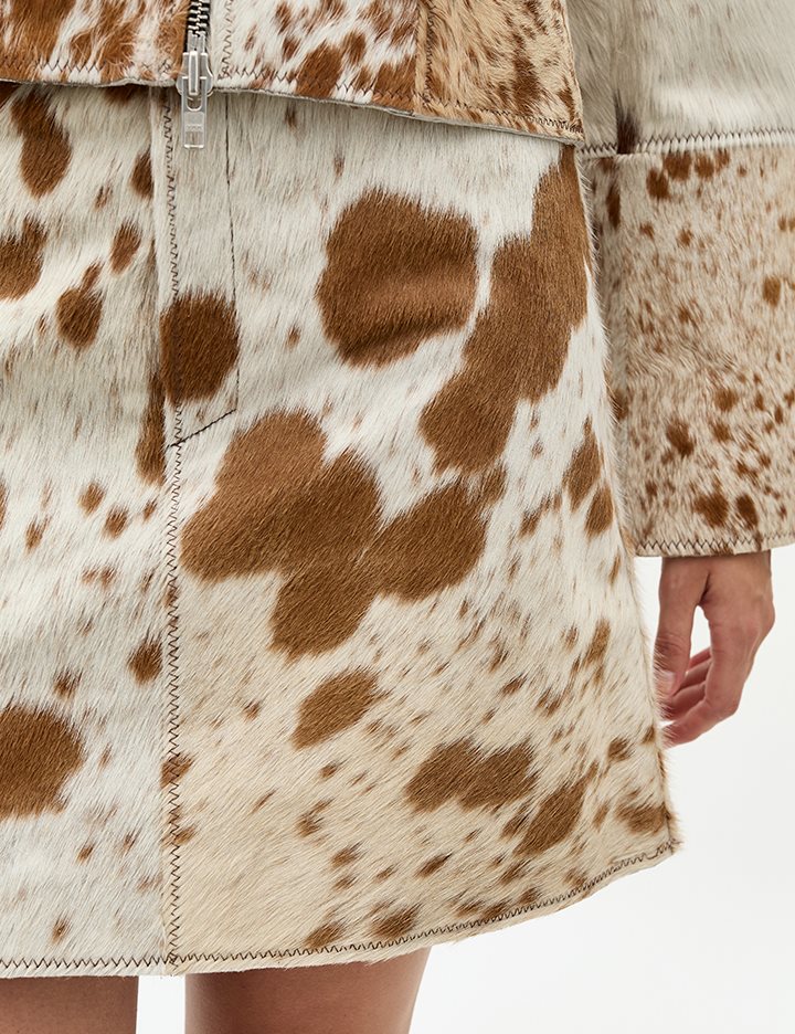 Capture attention in a genuine cow print skirt designed for bold women’s fashion. This tricolor cowhide skirt adds raw pattern and visual impact to any cowhide mini skirt outfit.