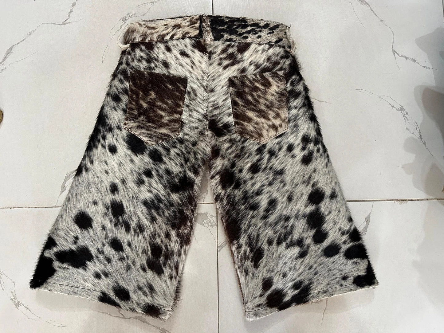 Genuine cowhide shorts for men with natural markings. Mid-rise fit, five pockets, and strong visual texture in a one-of-a-kind leather blend.