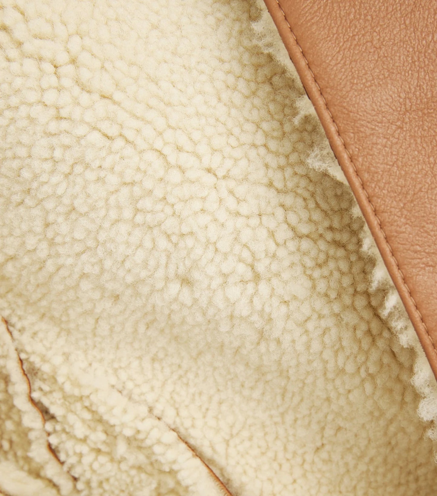 Close-up of a genuine leather coat, featuring rich texture, fine stitching, and a luxurious finish.