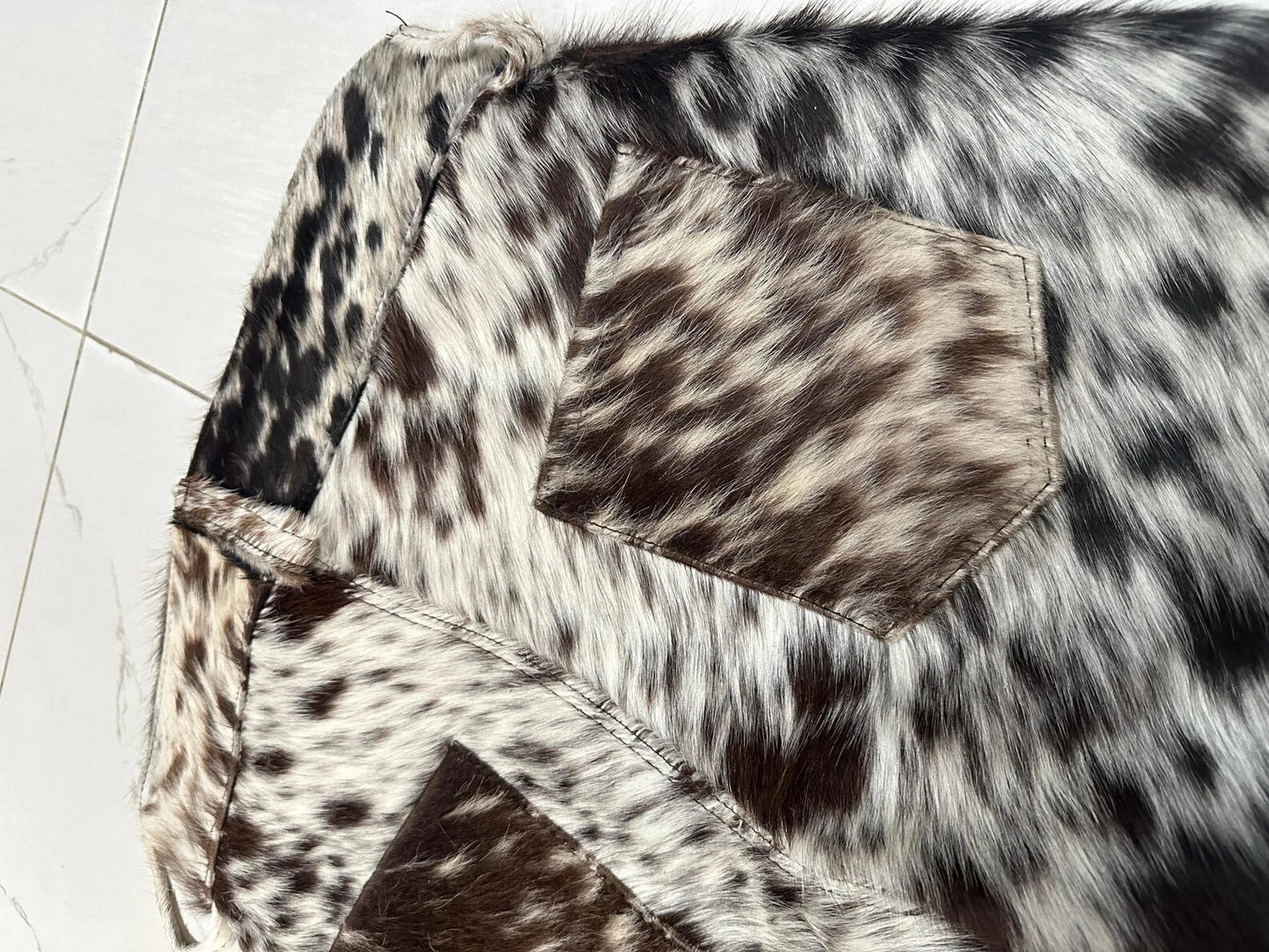 Men cowhide short made from real tricolor cowhide. Features flap pockets, folded hems, and a high-rise waist — each pair has unique leather patterning.