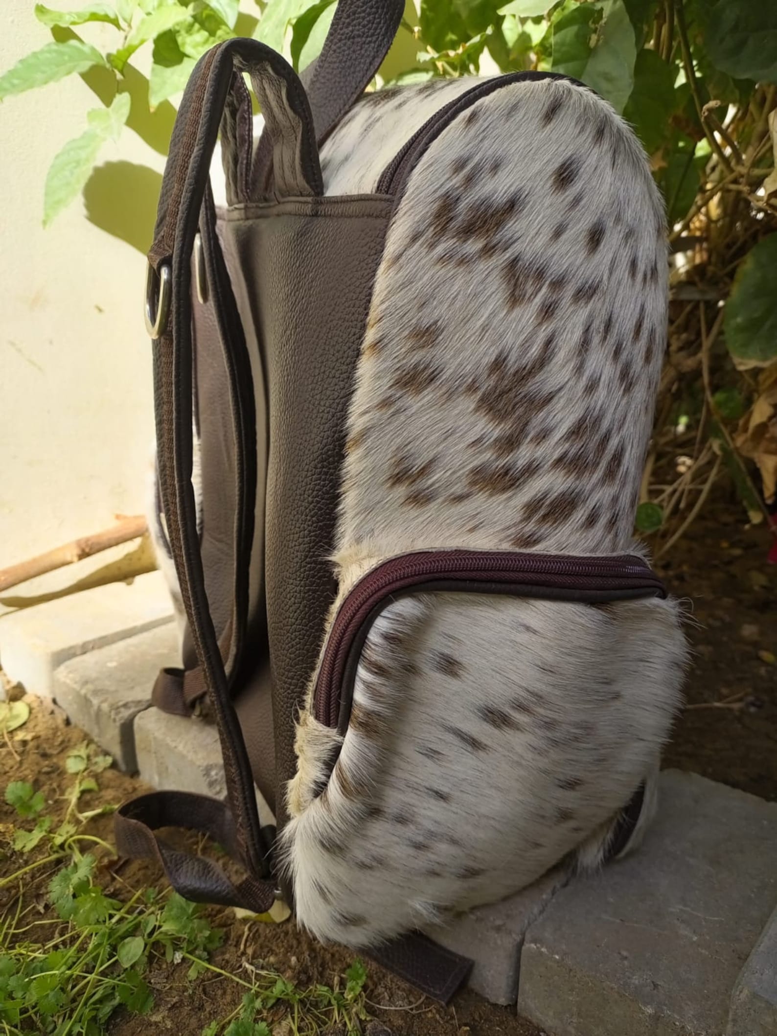 Stylish cowhide backpack with unique patchwork design and soft leather finish.