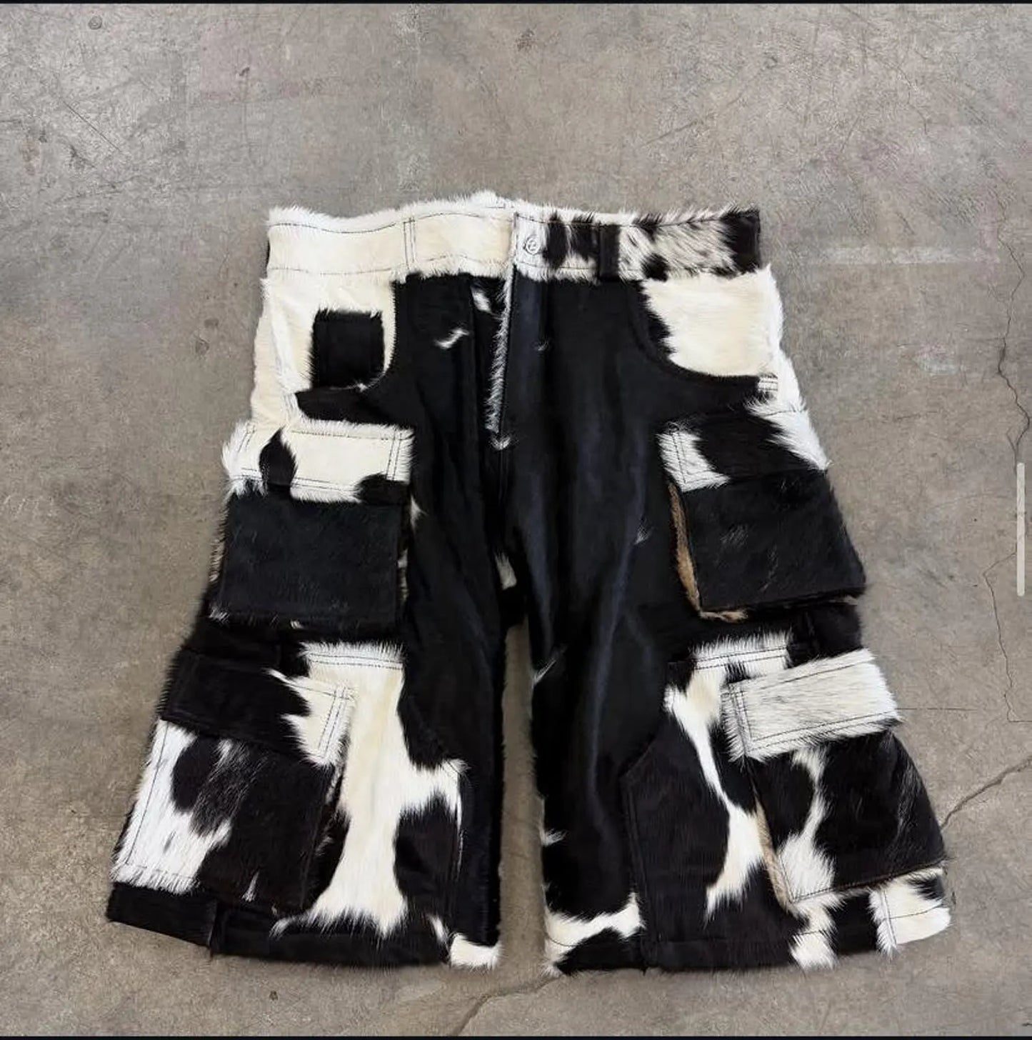 Kurze Hose aus echtem Kuhfellleder mit auffälligem Fellmuster, lockerer Passform und Cargotaschen. Perfekt für Rodeo, Festival oder Alltag.