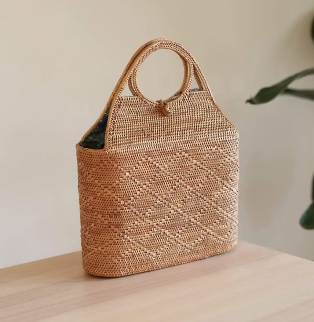 Bohemian rattan tote bag filled with flowers at a market stall.