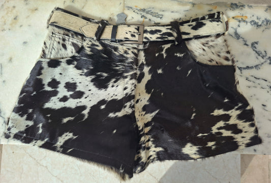 Real cowhide shorts for women featuring tricolor hair-on-hide, mini length, and back pockets. Bold cow print design made for western outfits and rodeo wear.