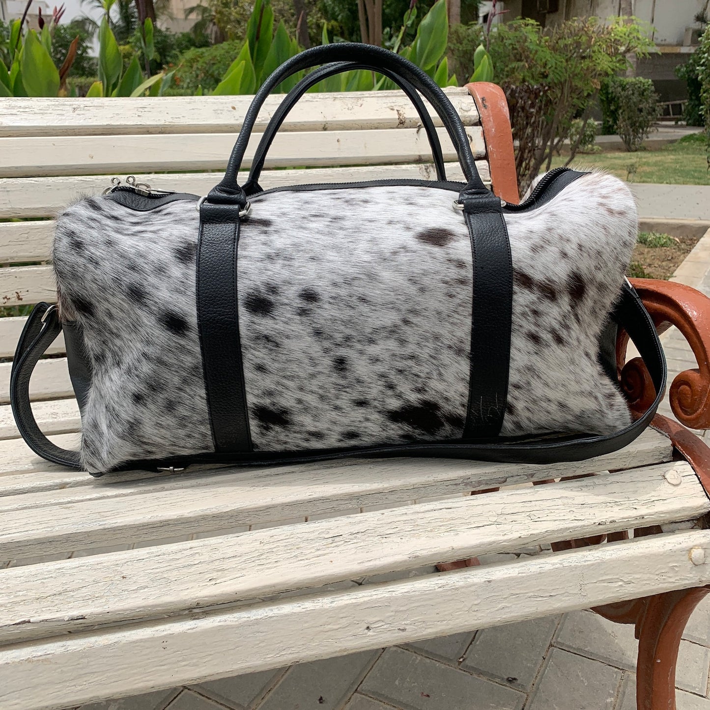 Elevate your escapades with this cow skin weekender bag, a symbol of wanderlust and refined taste for the modern traveler.