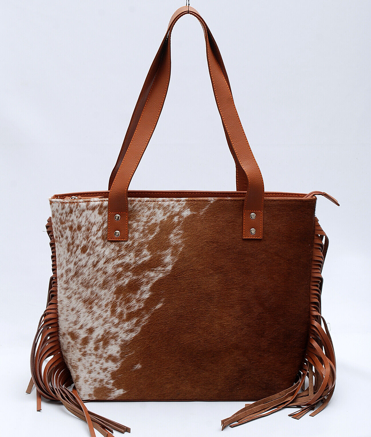 A western style cowhide purse for evening or weekend get away is the perfect accessory to take on any trip. This western-style, easy to carry bag will make any woman feel stylish and chic. 