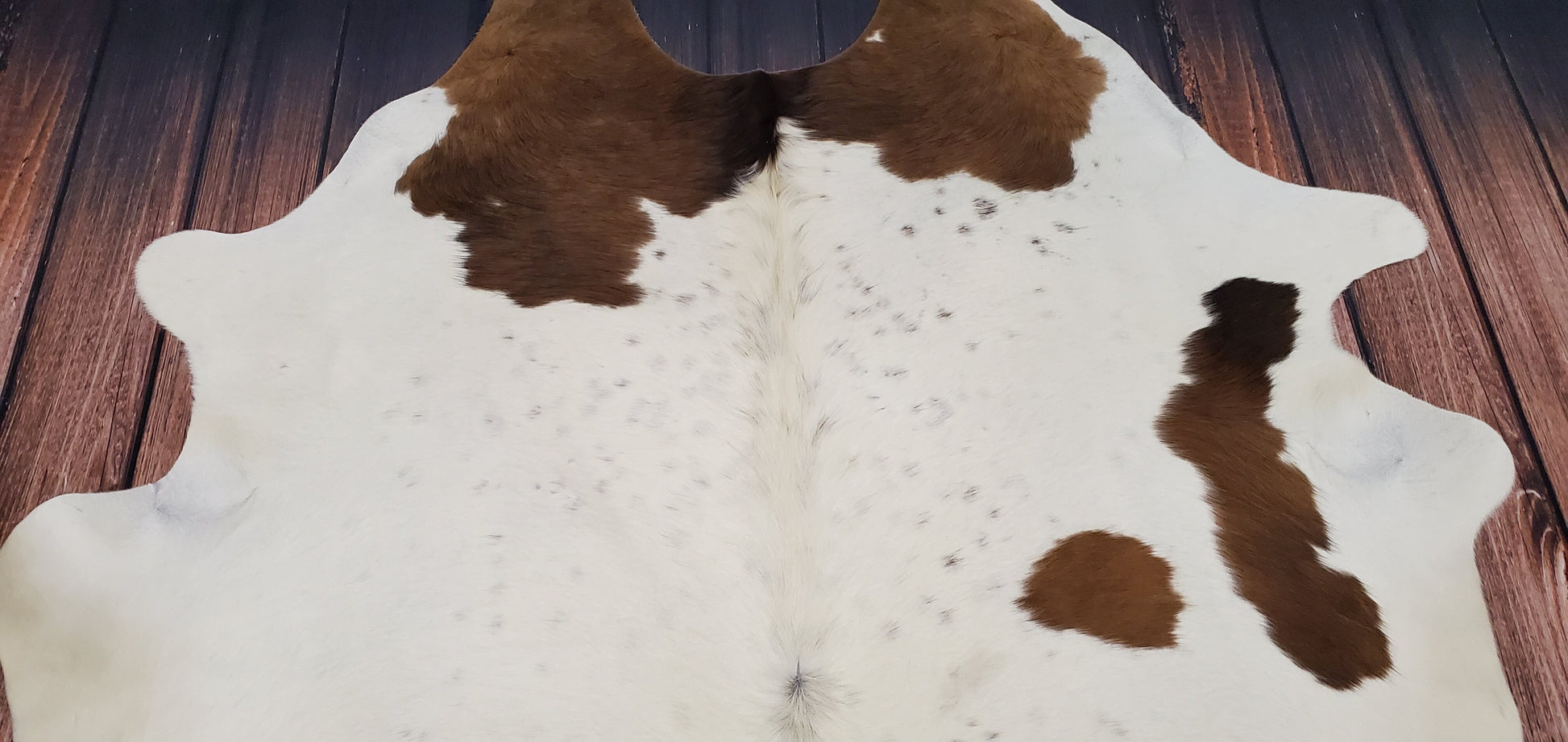 Add a unique touch to your home with this beautiful natural cowhide rug from the plains of Texas. Its brown and white coloring will bring a warm and inviting feel to any room.