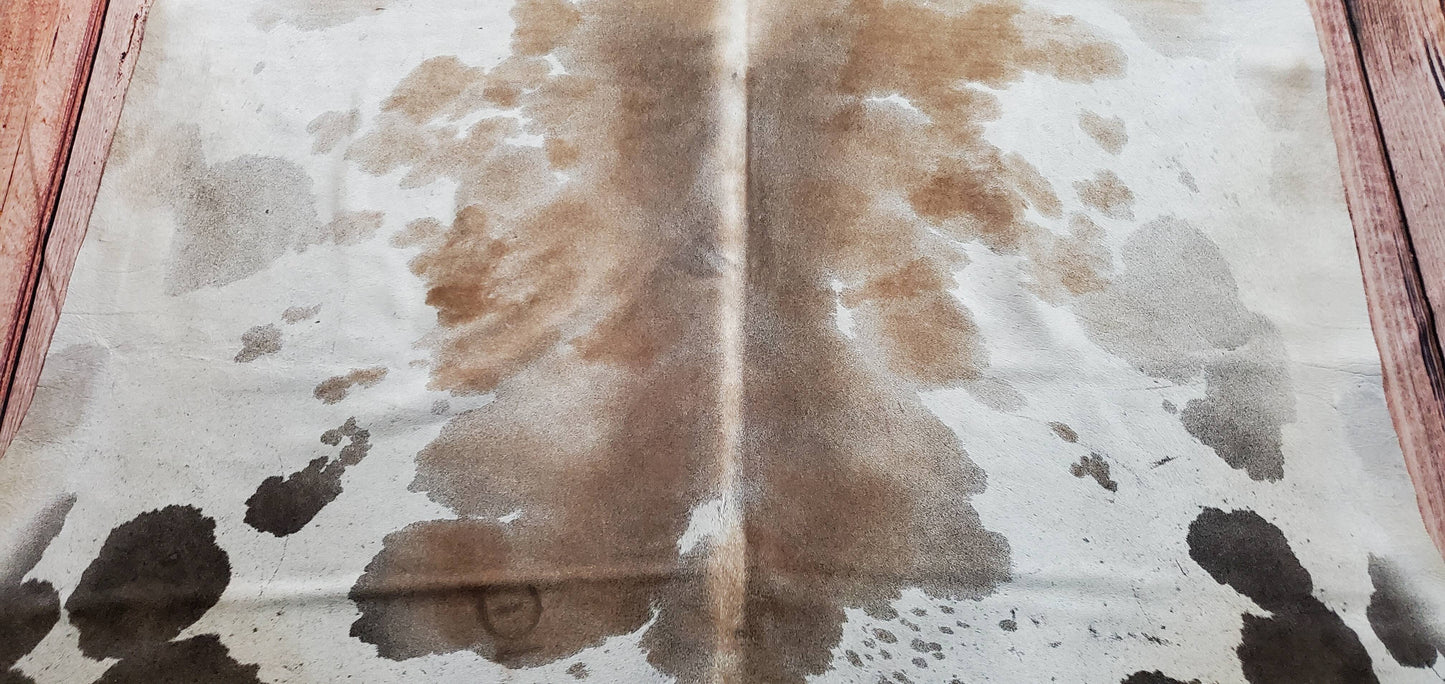 This large tricolor cowhide rug handpicked in Brazil, very soft and stunning, back finished is finished to sued and premium Brazilian. This large cowhide rug is beautiful, the dark brownish, grey and tan is stunning and it will look gorgeous in any space plus its free shipping all over the USA.