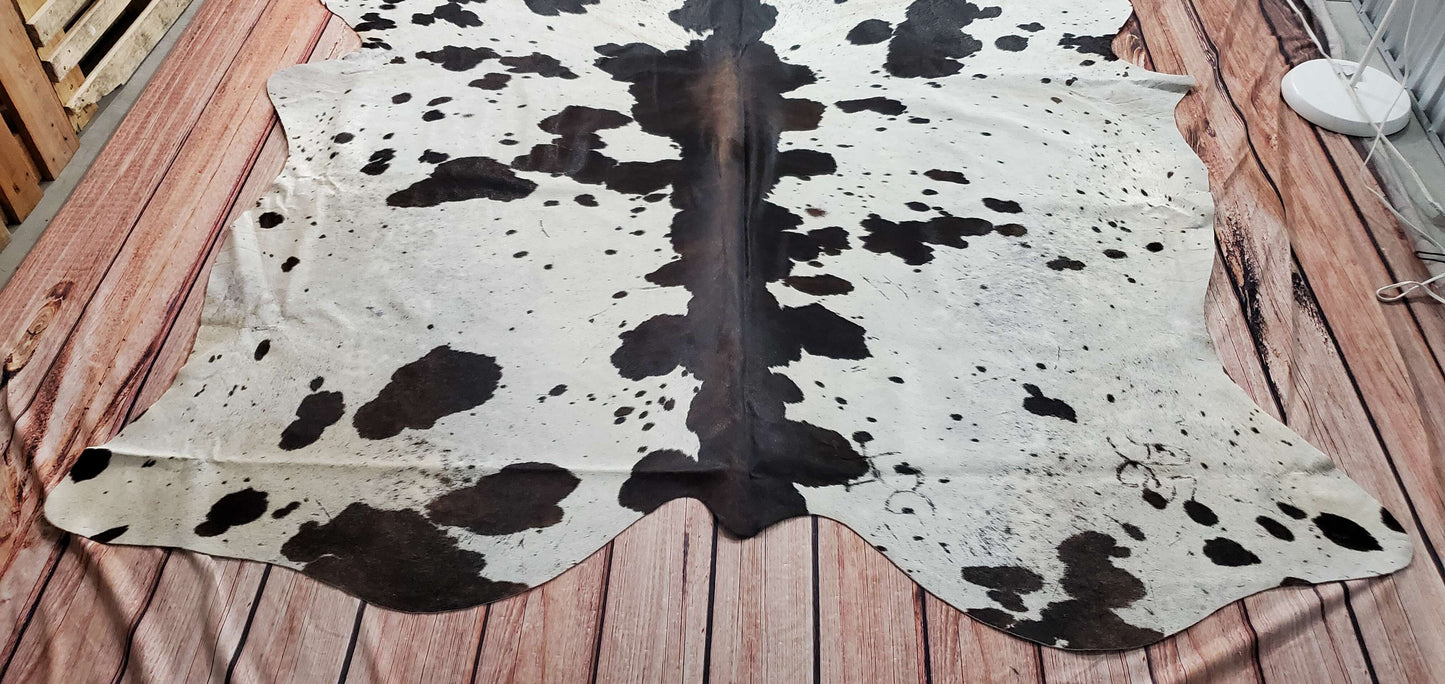 This beautiful cowhide rug is so comfortable and soft! It's mostly black, with some white speckled throughout, and it tends to enhance the looks of almost any room furniture.