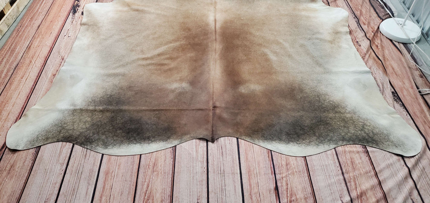 These cowhide rugs in a grey tan and soft yellow look terrific underneath a small number of chairs for protecting the floor and enhances the overall look of the room.