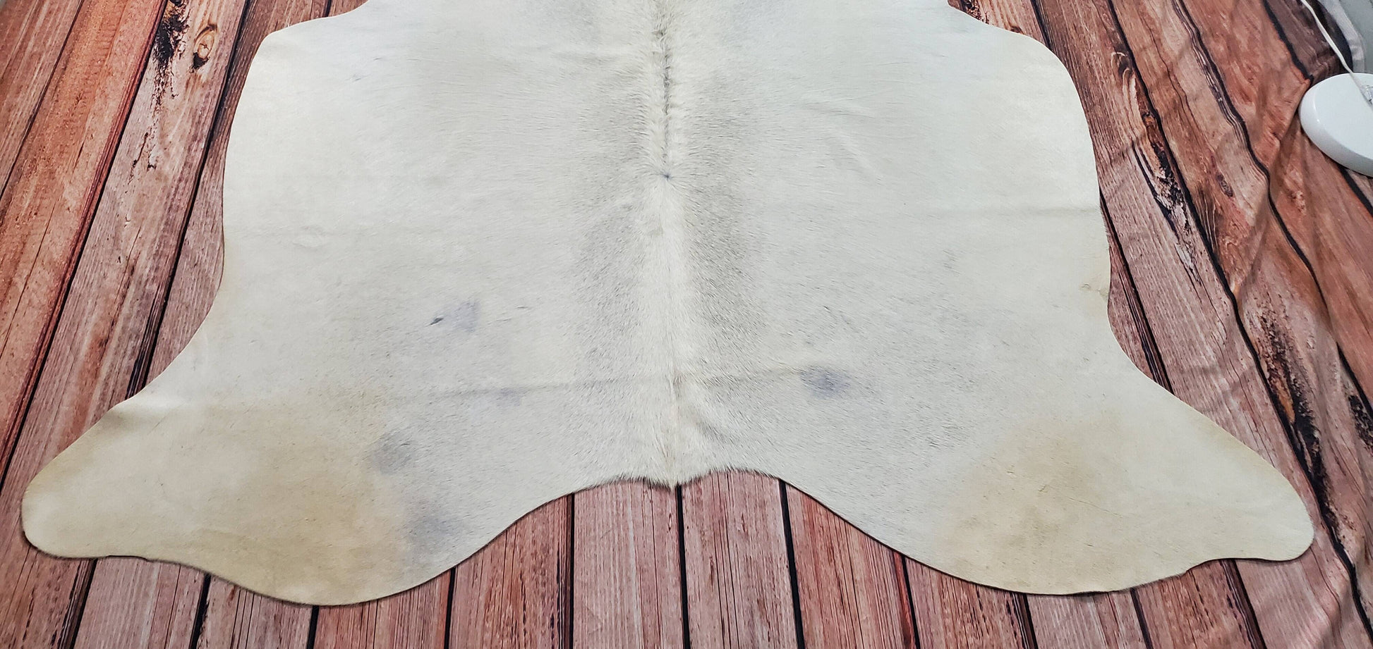 This grey ivory cowhide rug can function well in a variety of different settings, such as on a front porch or inside as a dining room floor