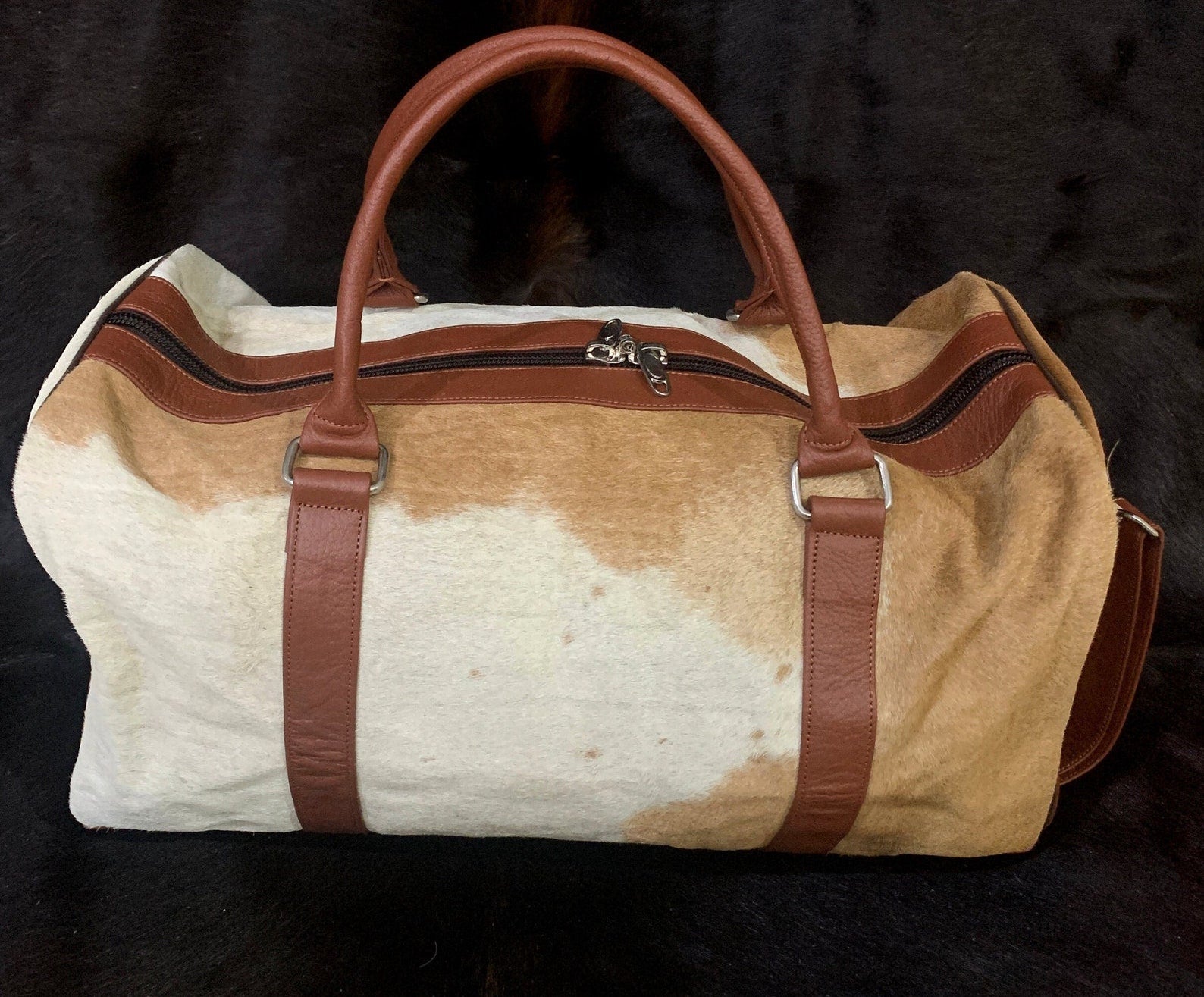 Experience sophistication on your journeys with this cow skin travel bag, designed for comfort and durability.