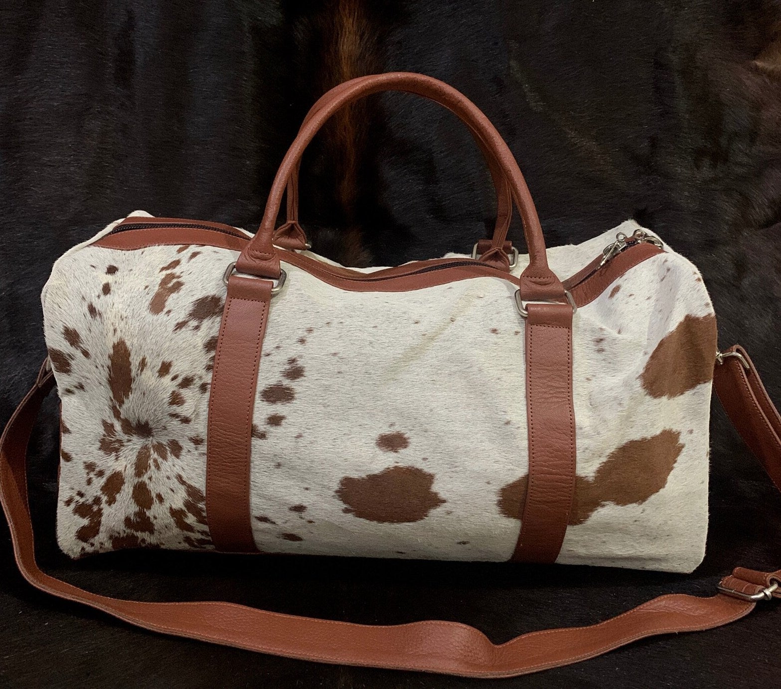 Discover the perfect cowhide bag that is lightweight, durable, and spacious! Our leather bag has a main compartment and an inside pocket to keep your belongings safe. Get the best travel bag today!