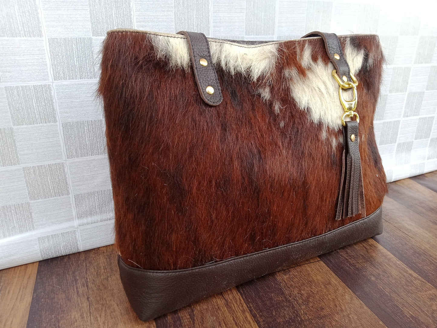 Each tricolor cowhide tote bag is handmade by experienced artisan leather craftsmen who carefully stitch together each individual piece of cowhide for superior quality.