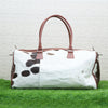 The inside of the cowhide luggage bag features two large compartments with plenty of room for packing clothes or other travel items. It also has an additional zippered pocket at the back which is ideal for storing valuables securely when out and about.