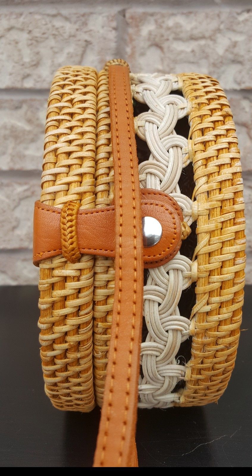Handcrafted rattan bag in a boho design, paired with flowers and sunglasses, perfect for a summer vibe.