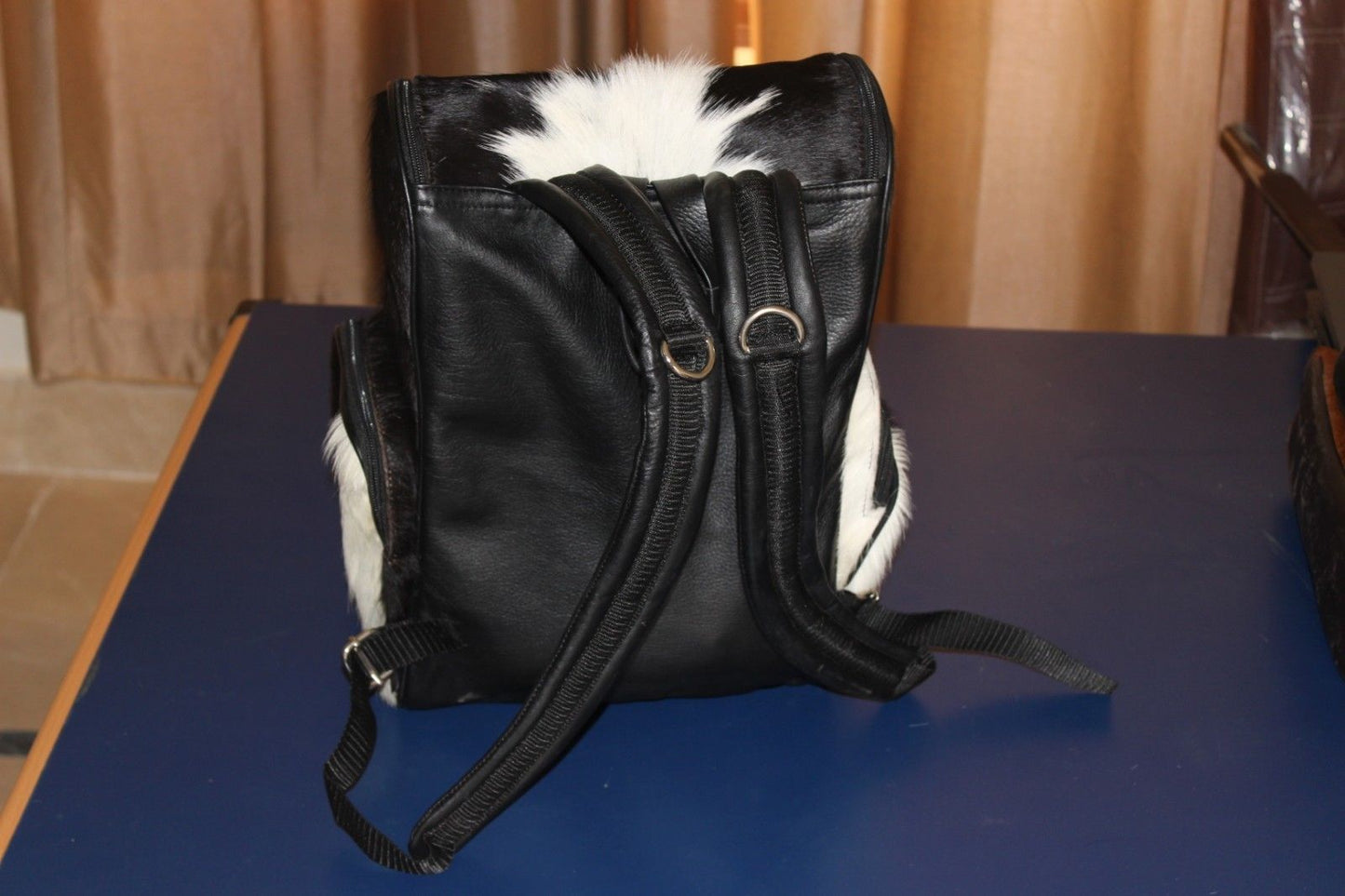 You will really like the sturdy cowhide bag It's going to fit everything and keep you comfy and for a long plane ride handles, zipper stitched well
