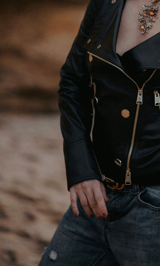 a woman wearing a black leather jacket and a necklace