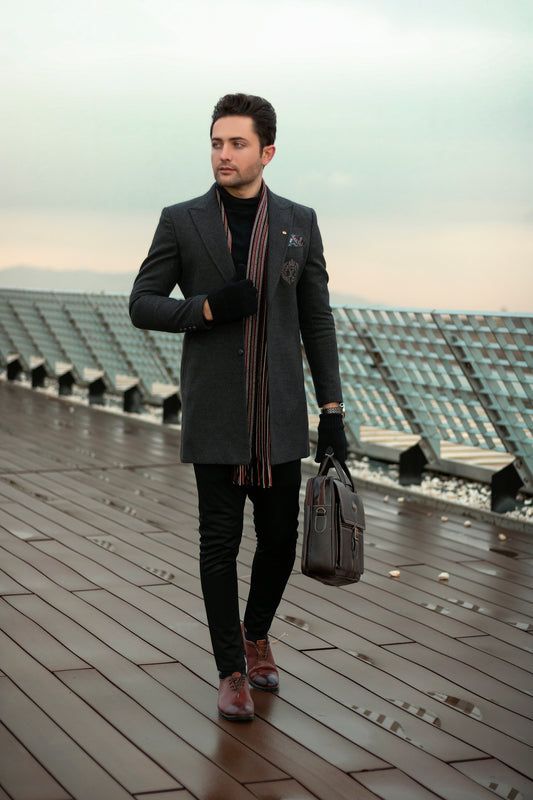 a man in a suit and scarf walking on a wooden floor