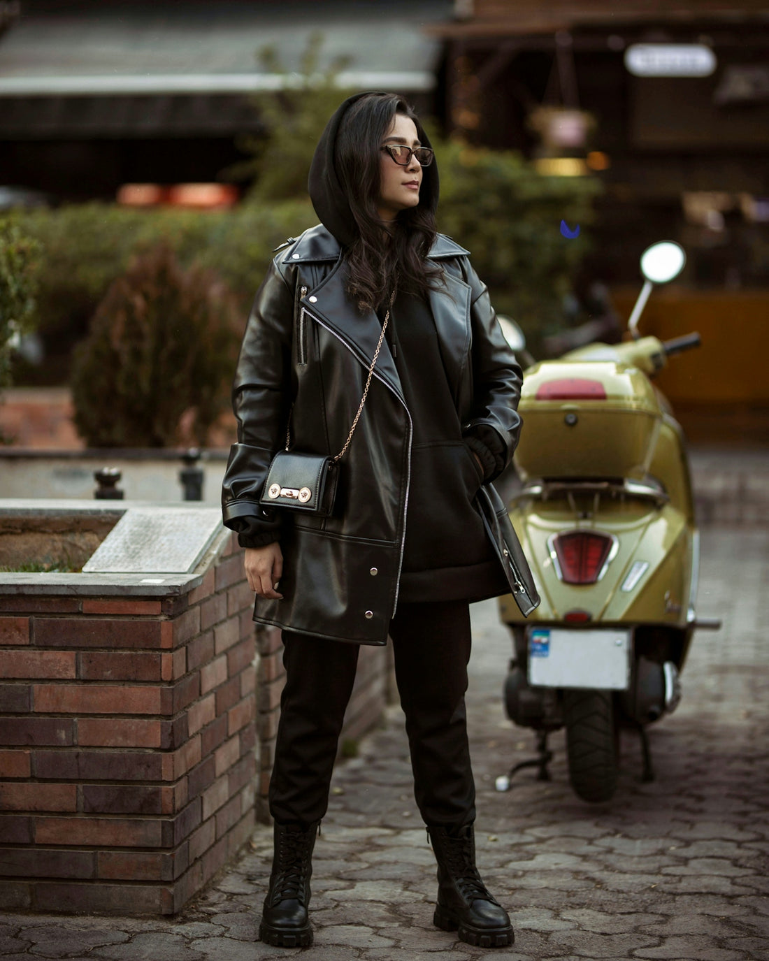 a woman wearing a black leather jacket and boots