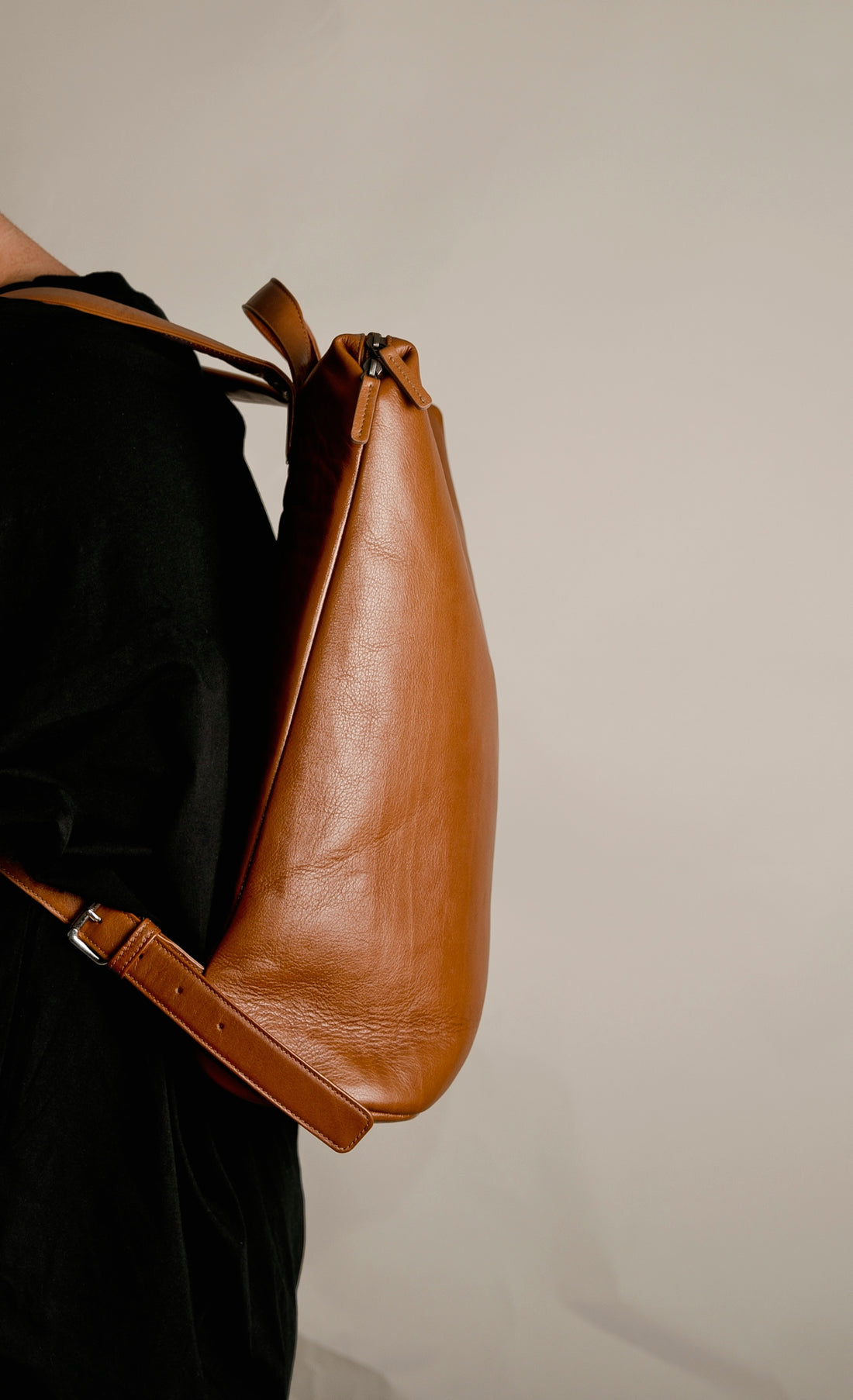 a woman is holding a brown leather bag