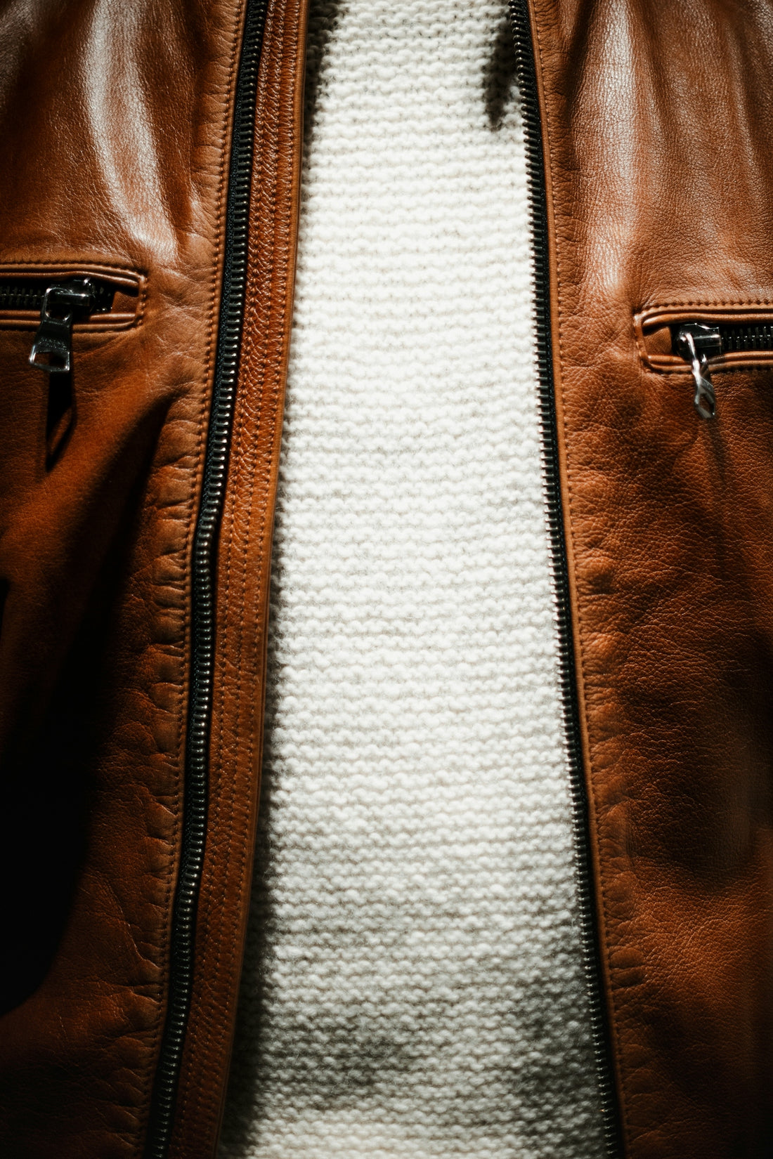 a close up of a person wearing a brown leather jacket