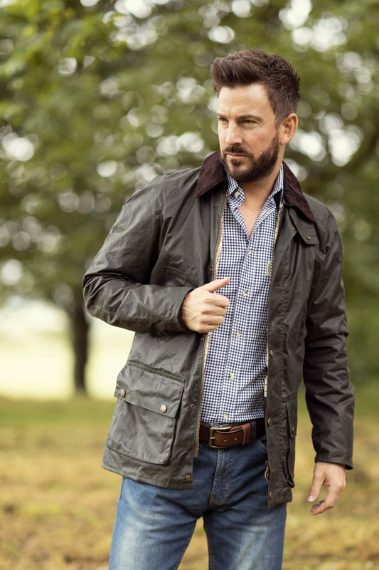 A man standing in a field with trees in the background