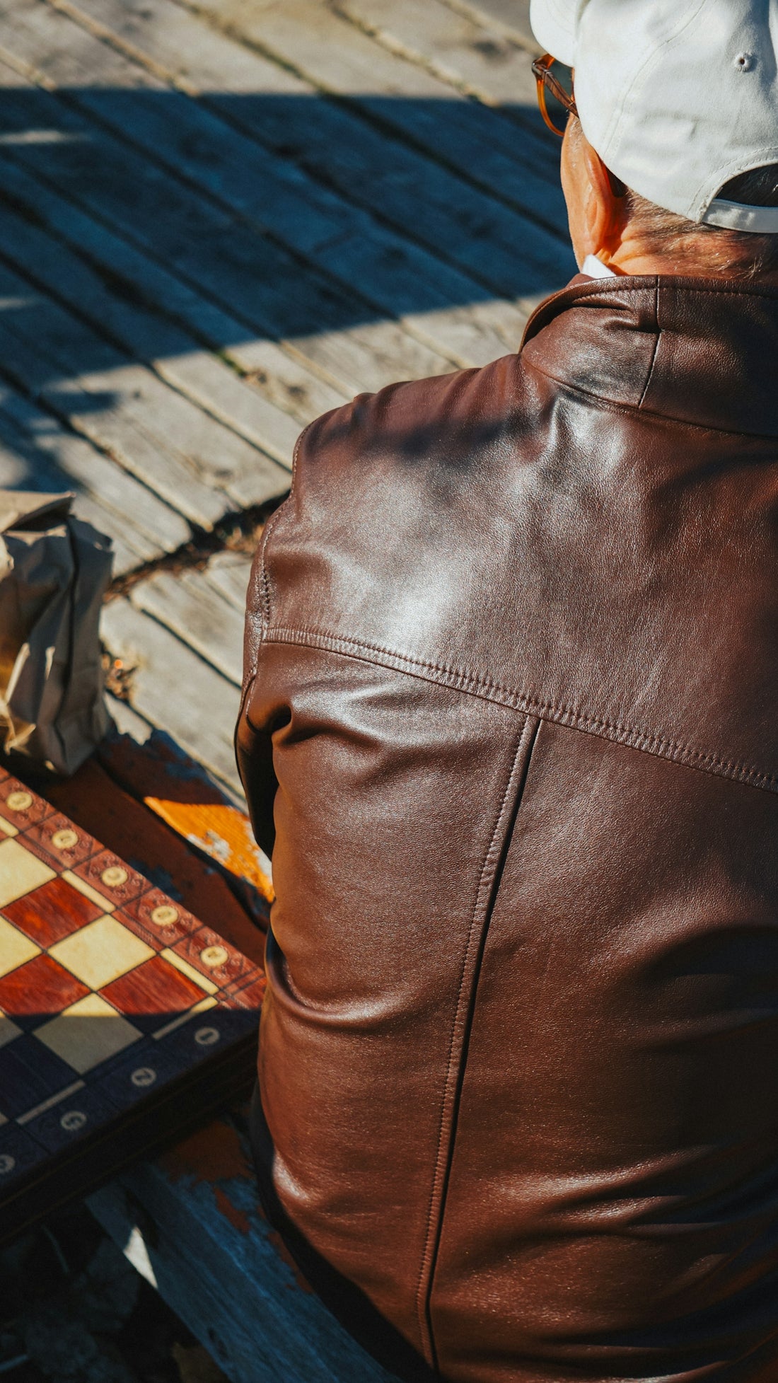 Man in a leather jacket with a chessboard.