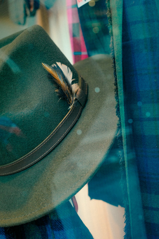 Green felt hat with feather detail.