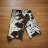 Men’s cowhide leather shorts featuring natural black, brown, and white patterns. Hair-on cow skin design perfect for western styling and outdoor wear.


