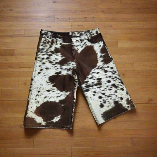Men’s cowhide leather shorts featuring natural black, brown, and white patterns. Hair-on cow skin design perfect for western styling and outdoor wear.

