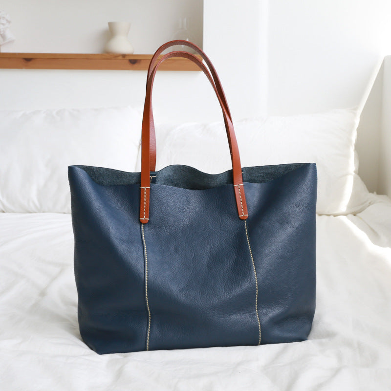 Real cowhide leather tote with top handle and zipper, offering a clean, organized layout for women’s work and travel needs.