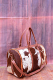 Hit the road, hit the gym, hit the rodeo. Handcrafted cowhide weekender. Durable, unique.