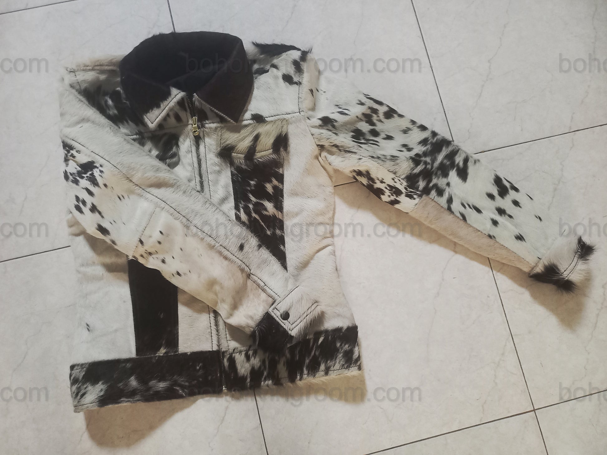 Bold cow skin jacket for outdoor gatherings and ranch living. Made from 100% cowhide leather with natural black and white grain and structured western fit.

