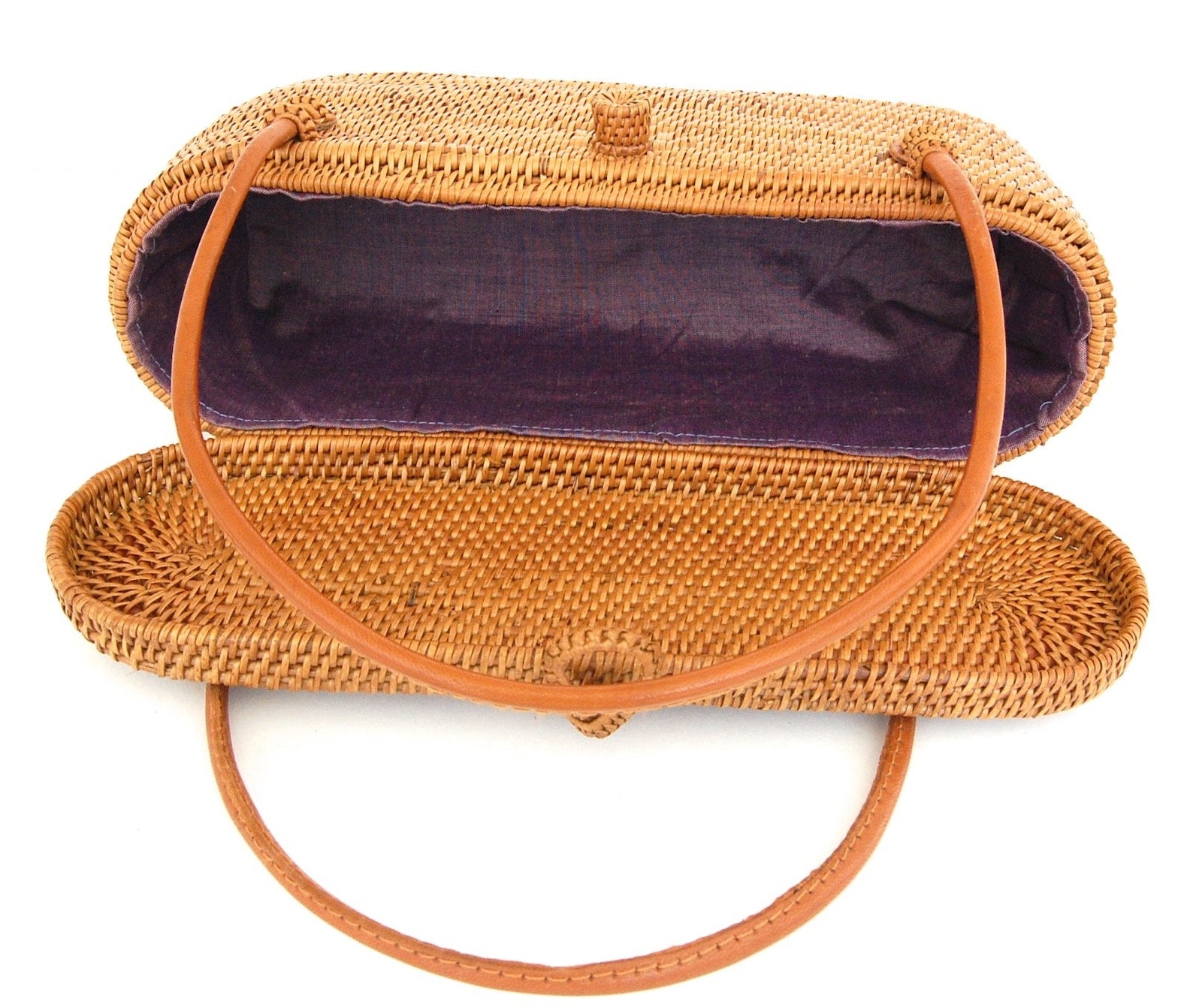 Beautifully woven rattan handbag featuring leather handles, ideal for daily use. A blend of natural materials and timeless design for any casual look.